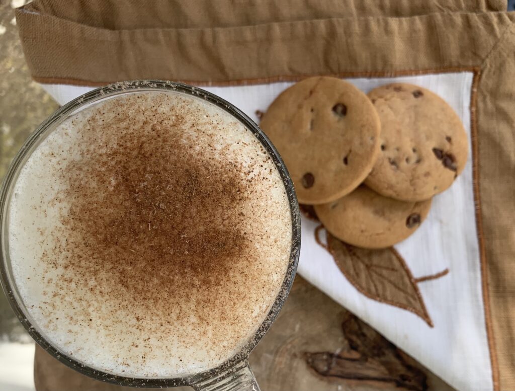 vista alzada del cappuccino junto a unas galletas 