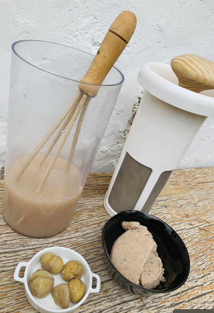 UNA JARRA CON LECHE DE CASTAÑAS JUNTO A PULPA DE CASTAÑAS Y CASTAÑAS COCIDAS