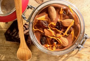 pudding de leche de avena y cacao con topping the pasas, almendras y naranja